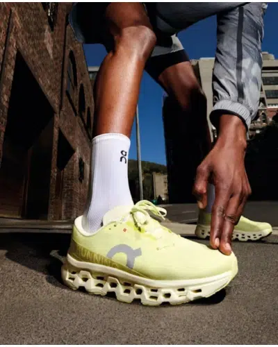 Close-up of neon On Running Cloud running shoes with a cushioned sole and breathable upper