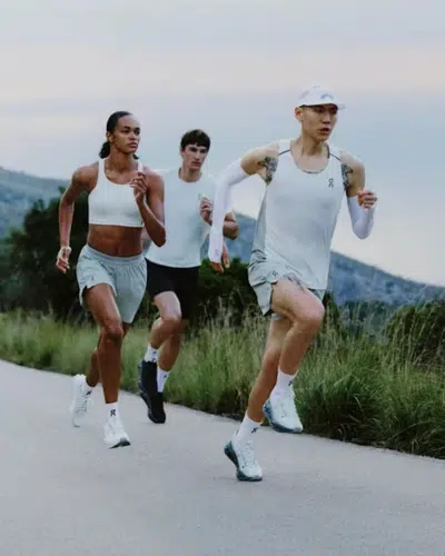 Athletes running outdoors wearing On Running Cloud running shoes in lightweight training apparel.